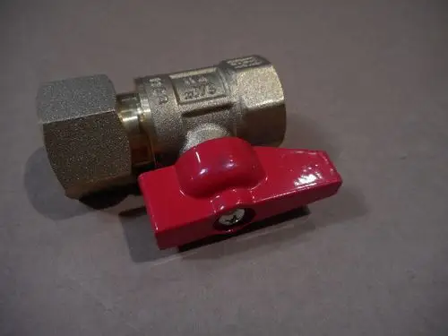 Kugelhahn aus Messing mit rotem Hebel, verwendet in Heizungs- und Sanitärinstallationen. Produkt von Remeha, einfach zu bedienen.